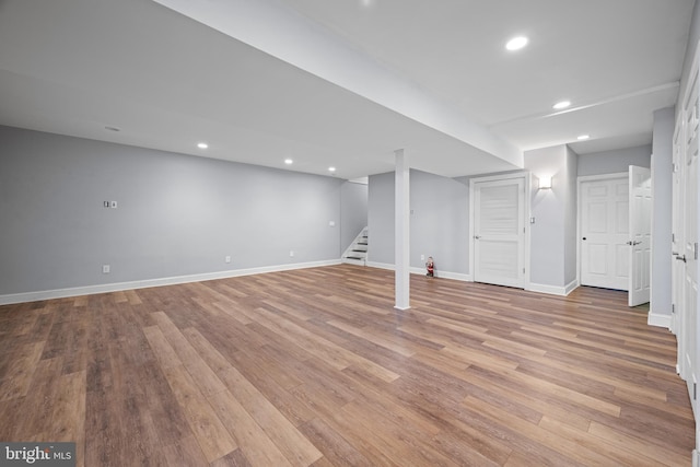 finished basement with recessed lighting, baseboards, wood finished floors, and stairs