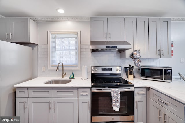 kitchen featuring stainless steel electric range, freestanding refrigerator, gray cabinetry, a sink, and under cabinet range hood