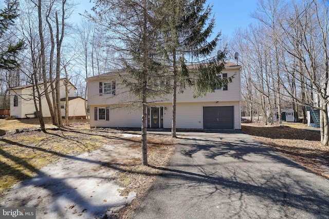 colonial home with aphalt driveway and a garage