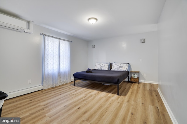 bedroom with wood finished floors, baseboards, a wall mounted air conditioner, and a baseboard radiator