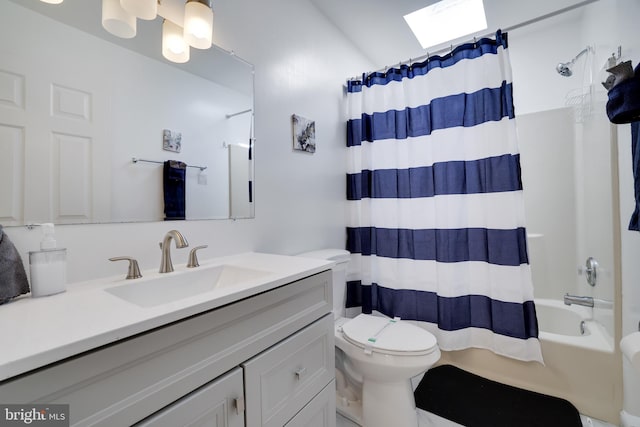 bathroom featuring vanity, a skylight, toilet, and shower / bath combo with shower curtain