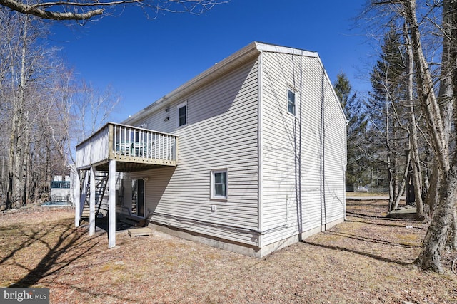 back of property featuring a deck and stairway