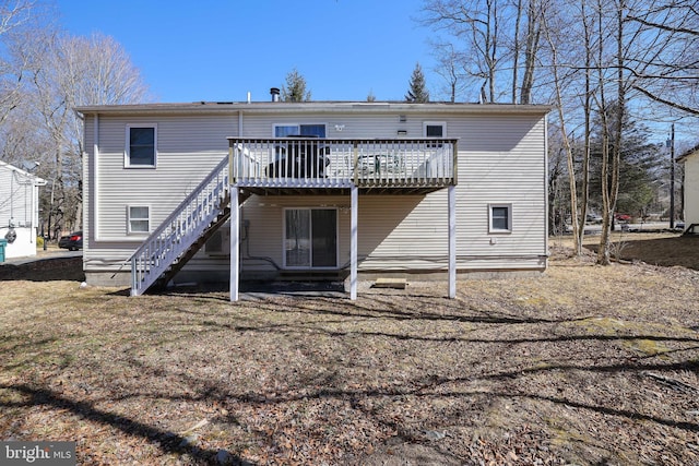 rear view of property featuring a deck and stairway