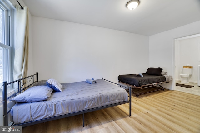 bedroom featuring light wood-style floors and ensuite bathroom