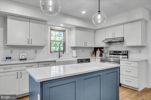 kitchen with under cabinet range hood, light wood-type flooring, light countertops, stainless steel electric range, and white cabinetry