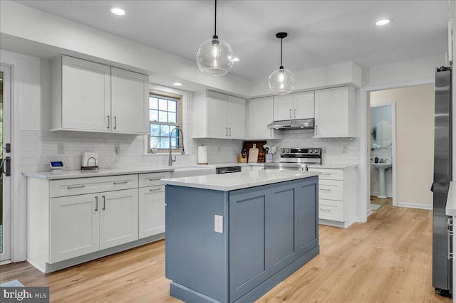 kitchen with under cabinet range hood, stainless steel electric range oven, light countertops, white cabinetry, and a sink