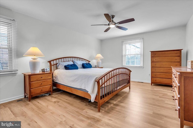 bedroom featuring light wood-type flooring, baseboards, visible vents, and a ceiling fan