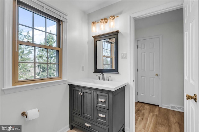 bathroom featuring vanity, wood finished floors, visible vents, and baseboards