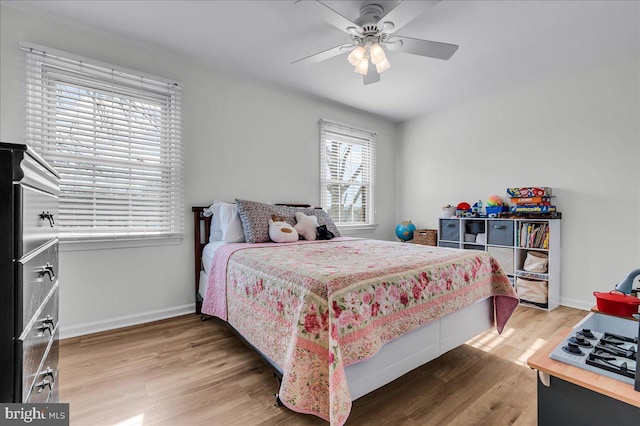 bedroom with a ceiling fan, baseboards, and wood finished floors