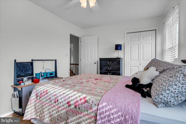 bedroom with a closet, baseboards, a ceiling fan, and wood finished floors