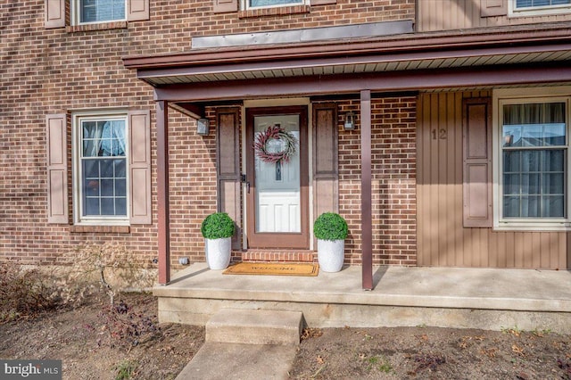 view of exterior entry with brick siding