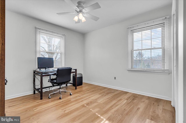 home office featuring baseboards, light wood-style floors, a healthy amount of sunlight, and ceiling fan