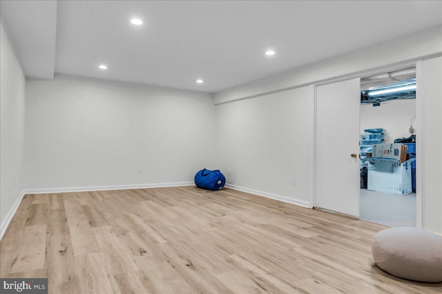 finished below grade area featuring recessed lighting, baseboards, and wood finished floors