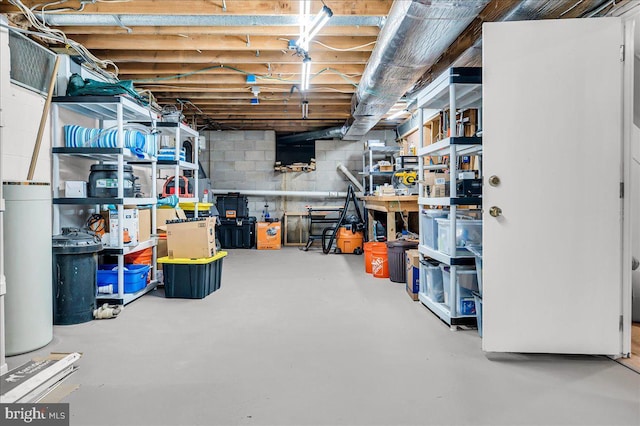 unfinished basement with a workshop area and concrete block wall