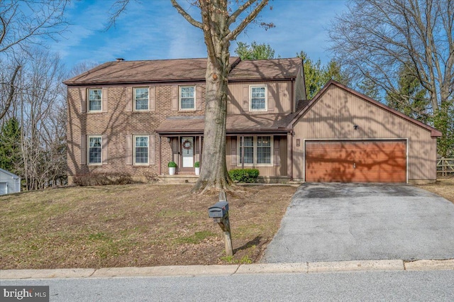 view of front facade with a front lawn, brick siding, a garage, and driveway