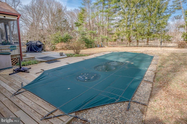 view of swimming pool featuring a grill, a deck, and fence