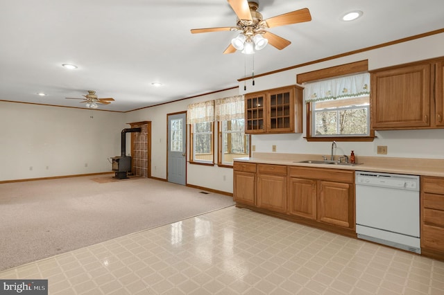 kitchen featuring baseboards, ornamental molding, a sink, light countertops, and dishwasher