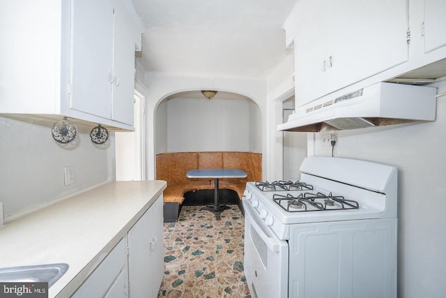 kitchen with white cabinetry, light countertops, gas range gas stove, and under cabinet range hood