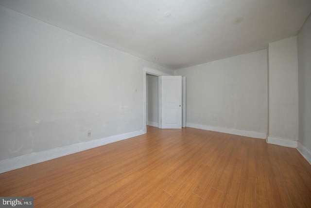 empty room with baseboards and light wood-style floors