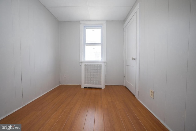 unfurnished bedroom featuring radiator heating unit and wood-type flooring