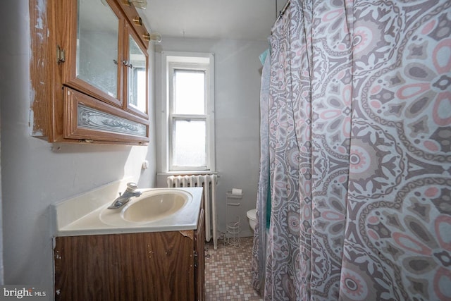 full bathroom featuring vanity, toilet, and radiator heating unit