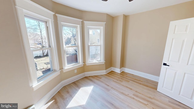 empty room with baseboards, light wood-style floors, and a ceiling fan