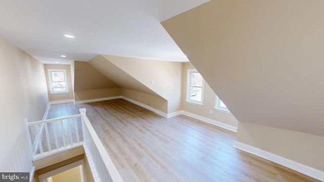 additional living space with recessed lighting, baseboards, wood finished floors, and vaulted ceiling