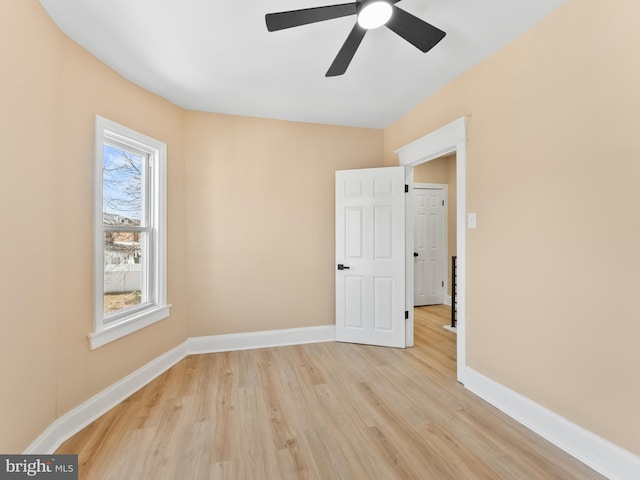 unfurnished room with baseboards, light wood finished floors, and ceiling fan