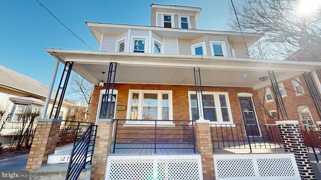 view of front of house with brick siding and covered porch