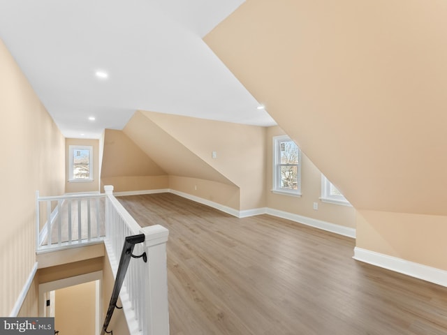 additional living space featuring baseboards, plenty of natural light, and light wood-style flooring