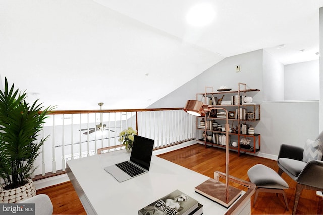 home office featuring a ceiling fan, vaulted ceiling, wood finished floors, and baseboards