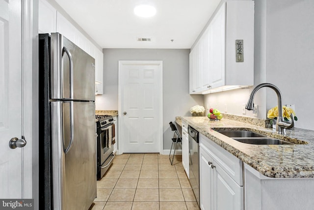 kitchen featuring visible vents, a sink, appliances with stainless steel finishes, white cabinets, and light tile patterned floors