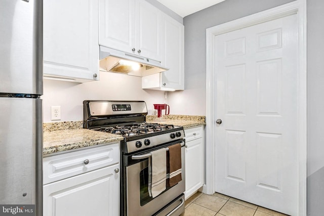 kitchen featuring under cabinet range hood, stainless steel appliances, light tile patterned flooring, and white cabinets