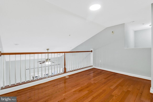 additional living space featuring vaulted ceiling, wood finished floors, baseboards, and ceiling fan