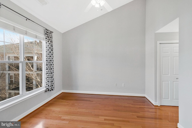 empty room with baseboards, visible vents, ceiling fan, vaulted ceiling, and light wood-type flooring