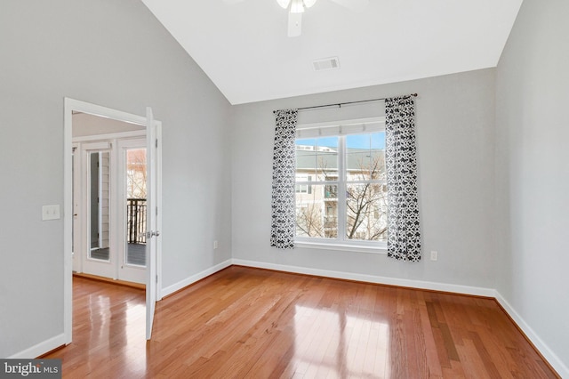 unfurnished room with visible vents, ceiling fan, baseboards, lofted ceiling, and wood finished floors