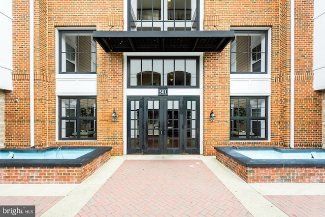 entrance to property with brick siding and french doors