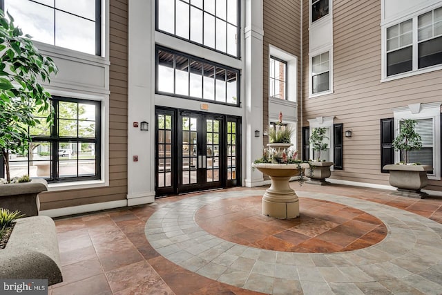 entrance foyer with stone tile floors, wooden walls, and a high ceiling