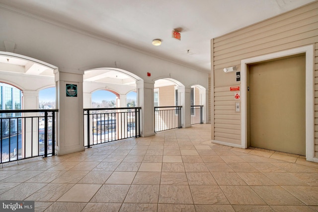 spare room featuring elevator and ornamental molding