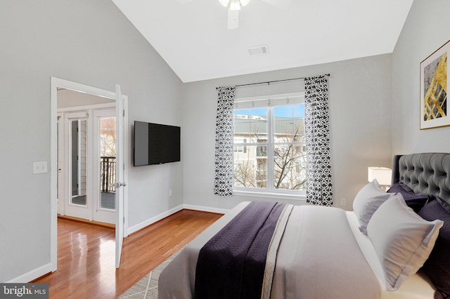 bedroom with visible vents, baseboards, vaulted ceiling, wood finished floors, and a ceiling fan