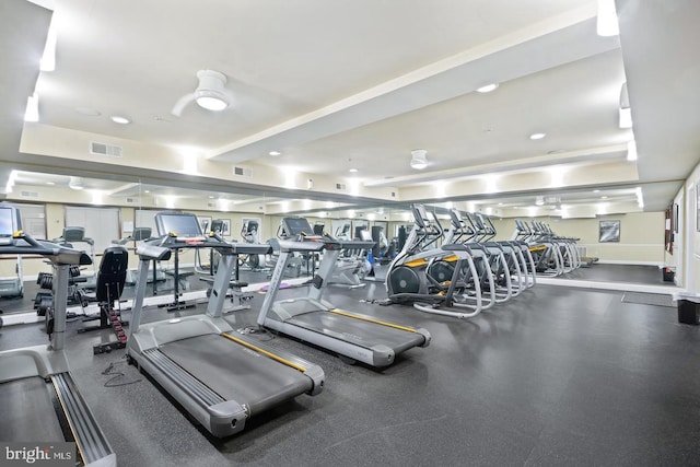 gym featuring visible vents, baseboards, and a raised ceiling