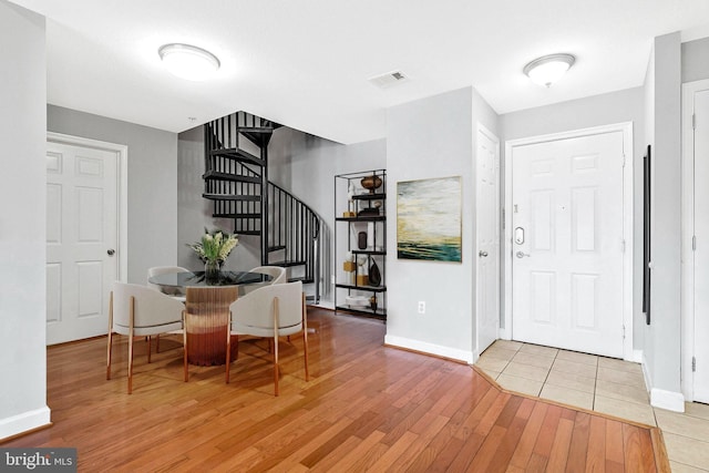 entrance foyer featuring stairs, baseboards, visible vents, and light wood-type flooring