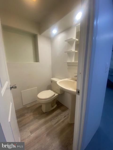 half bath featuring toilet and wood finished floors