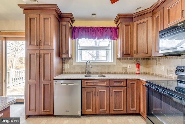 kitchen with a sink, decorative backsplash, brown cabinets, and black appliances