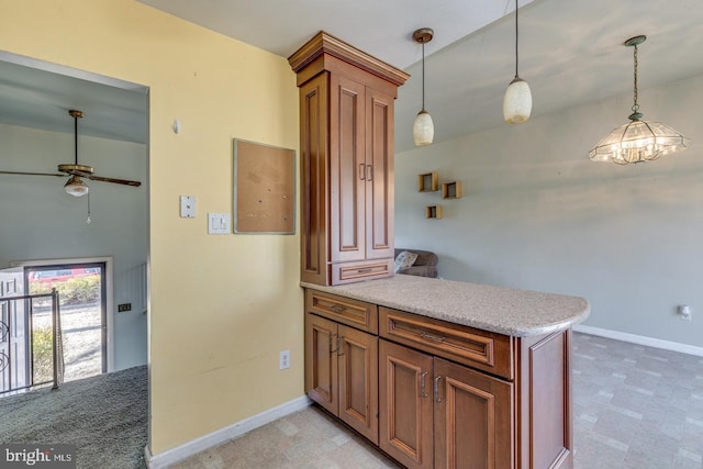 kitchen with a peninsula, decorative light fixtures, baseboards, and brown cabinets