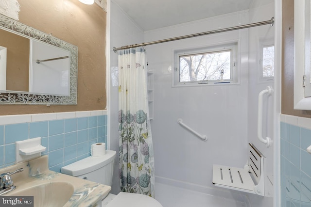 full bath with curtained shower, tile walls, and toilet