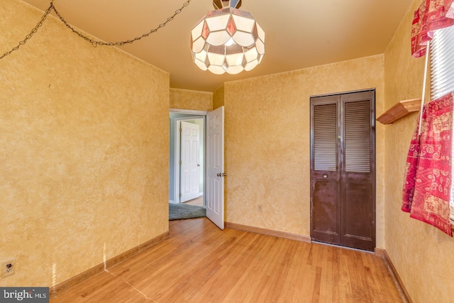 empty room featuring wood finished floors and baseboards