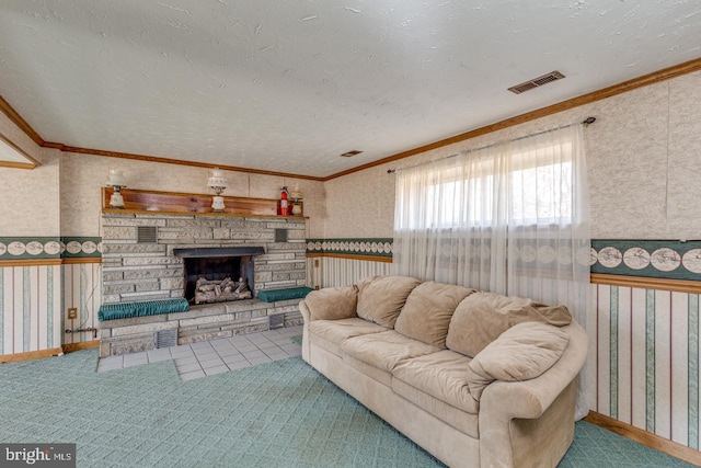 living area featuring visible vents, wallpapered walls, a fireplace, ornamental molding, and a textured ceiling