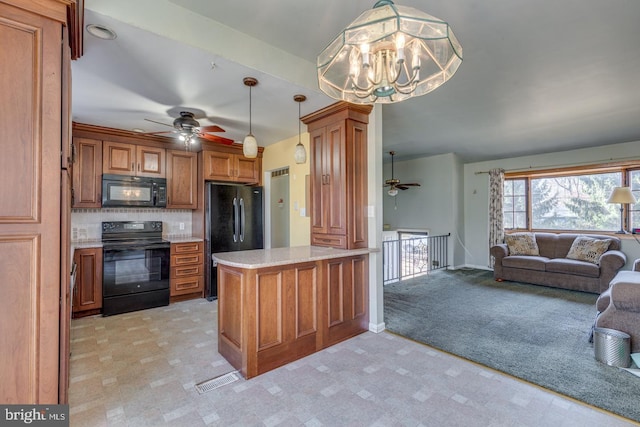 kitchen with brown cabinets, black appliances, decorative light fixtures, open floor plan, and a peninsula