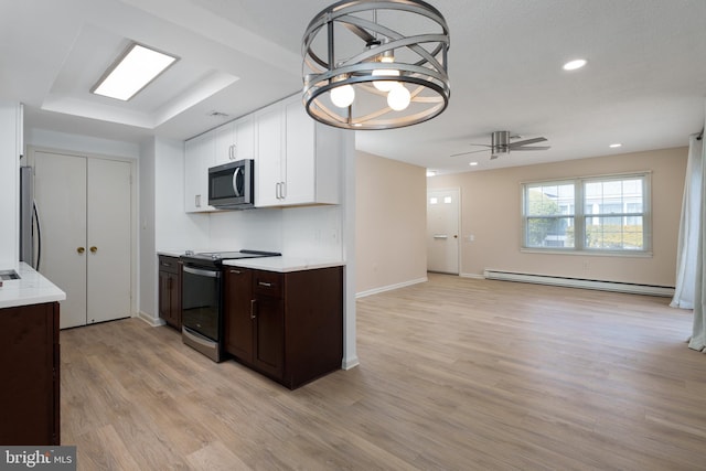 kitchen with white cabinetry, light countertops, baseboard heating, and stainless steel appliances